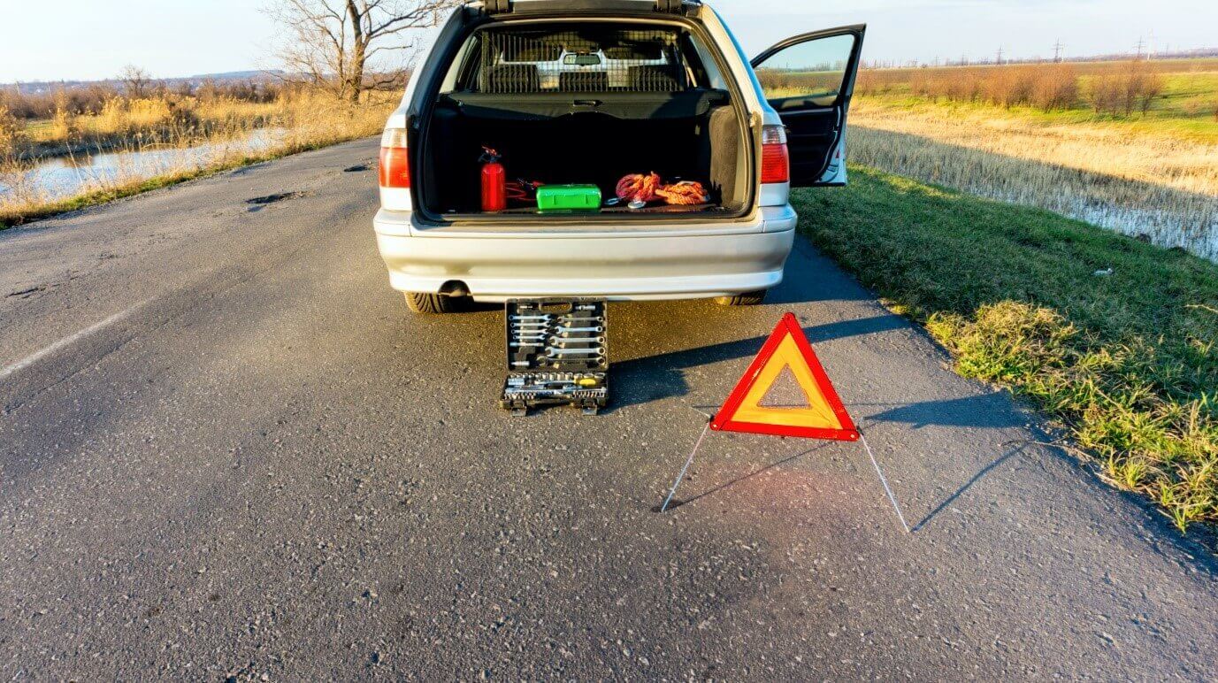 A car with a warning triangle behind it